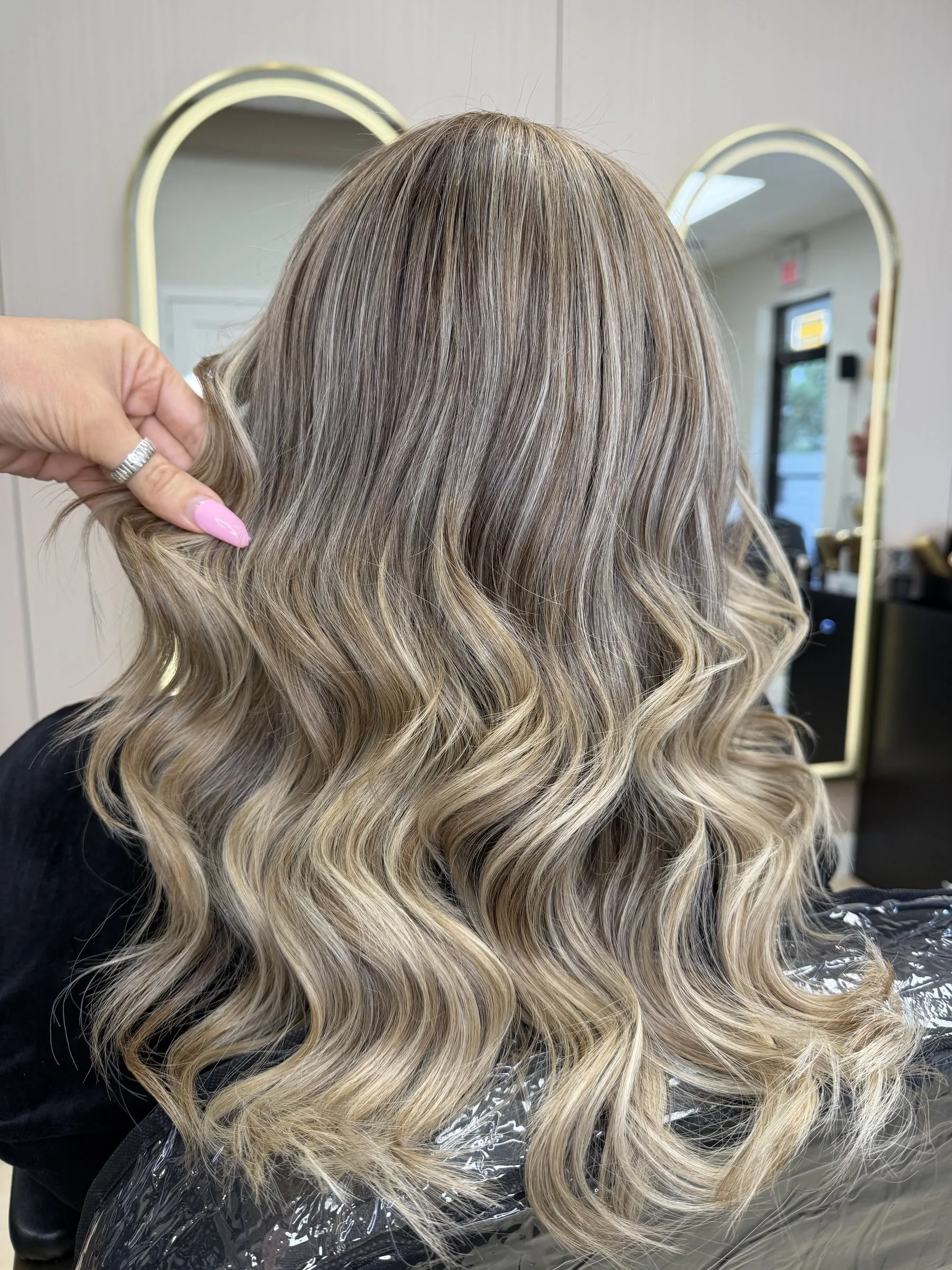 Ash blonde highlights on long waves by Ronak Hairstylist in Toronto