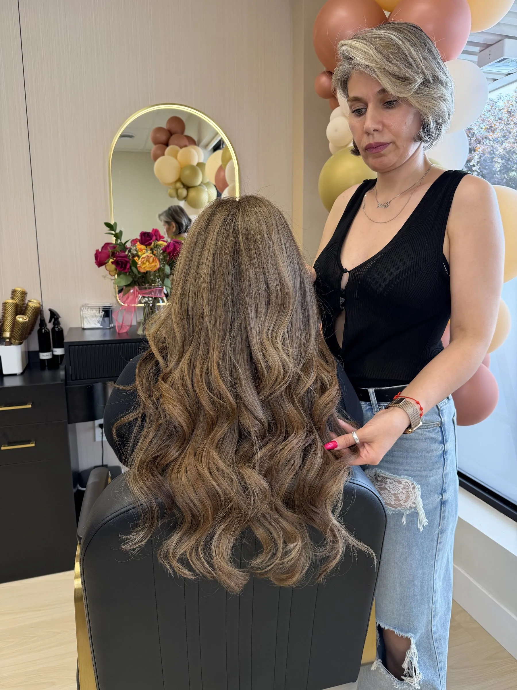 Ronak checking the finished color and waves on a client in her Toronto salon